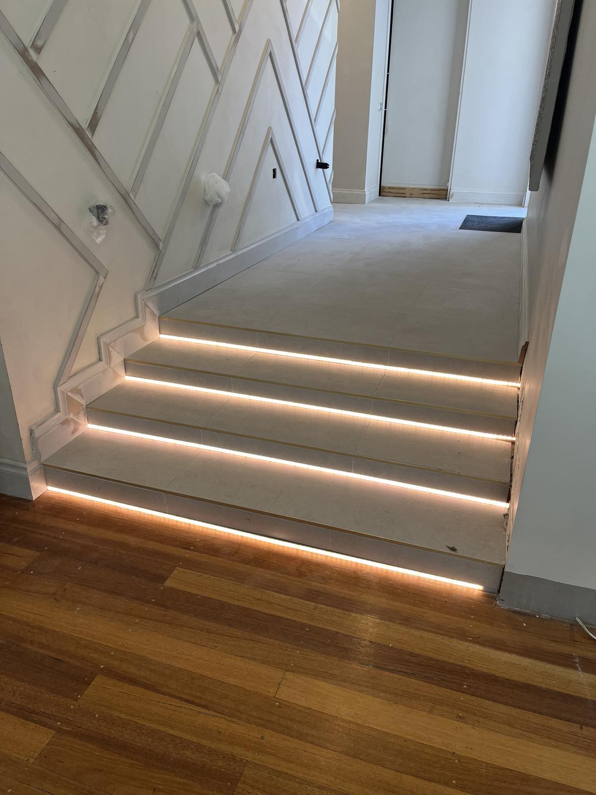 LED strip lighting recessed into each stair tread of a staircase, lit warm