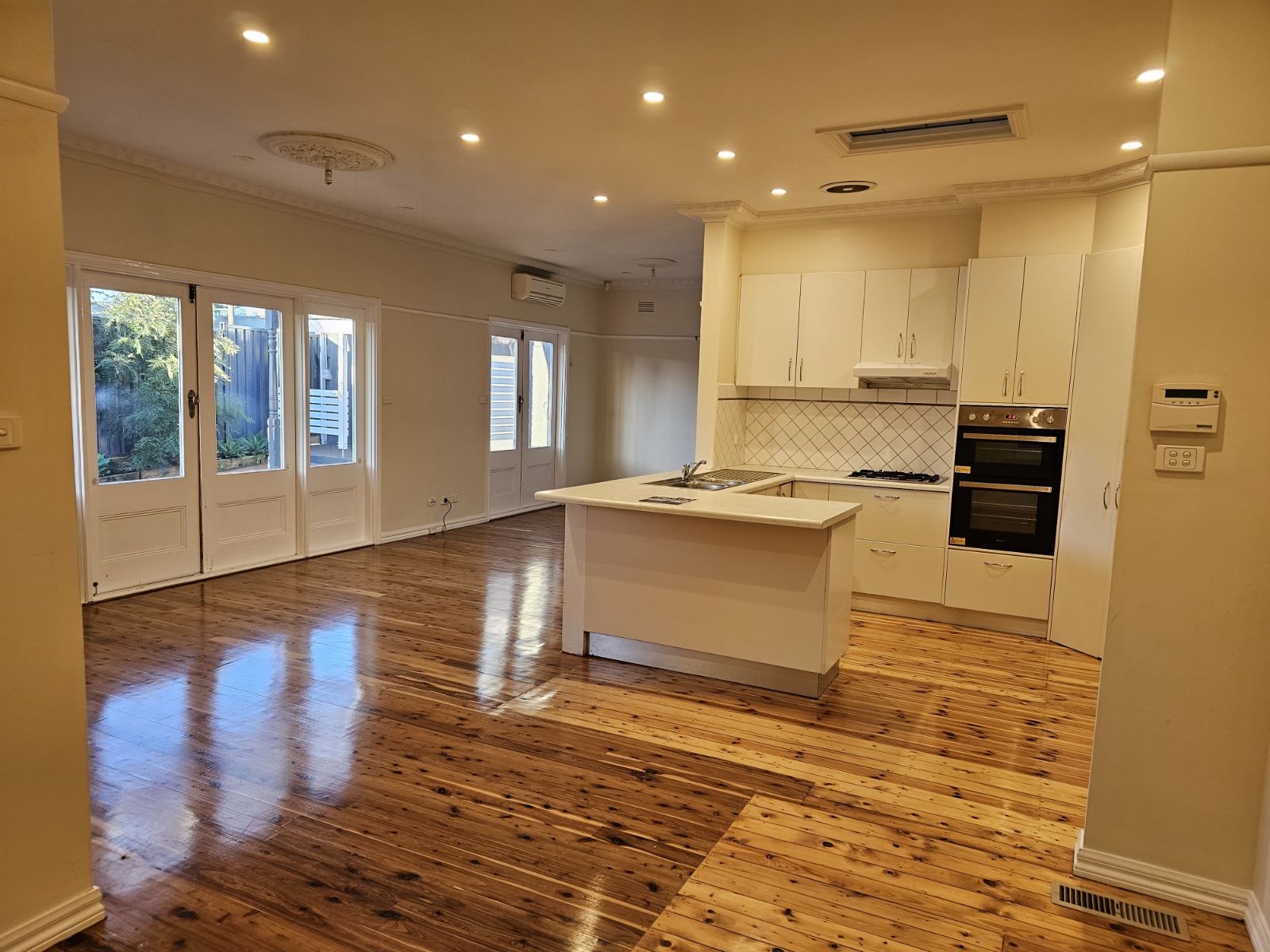Renovated open plan kitchen and living room with downlights throughout and the original ceiling rose kept