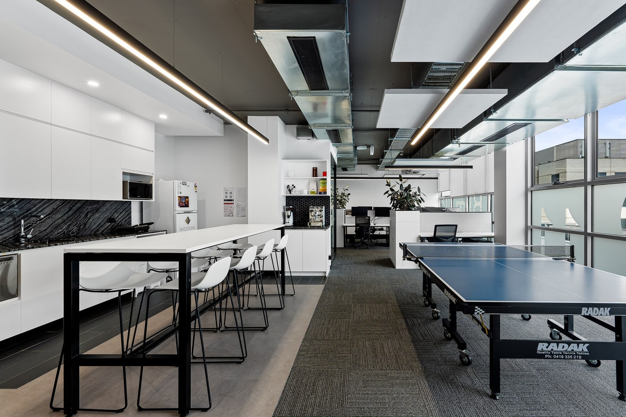 Office kitchen and breakout area lit by linear LED battens